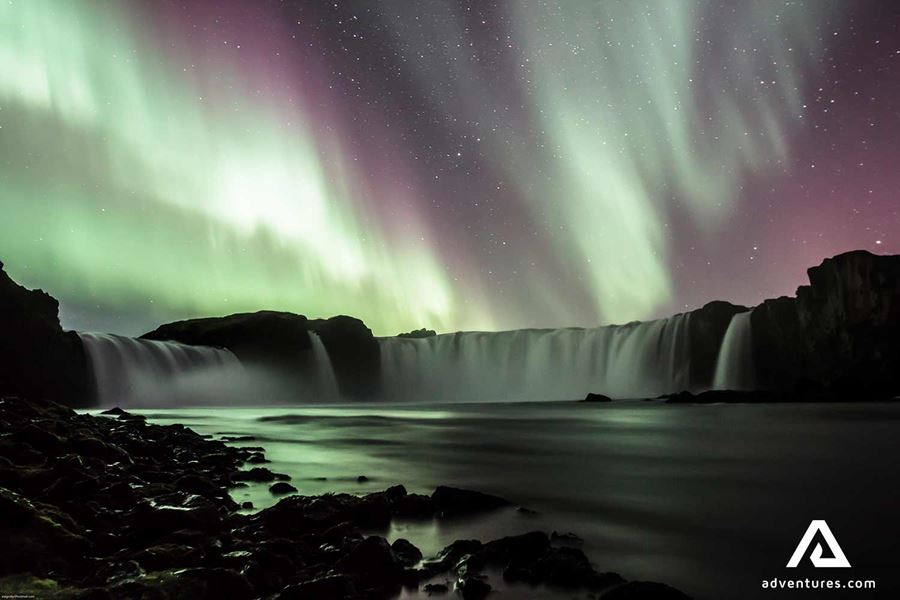 northern lights above godafoss waterfall