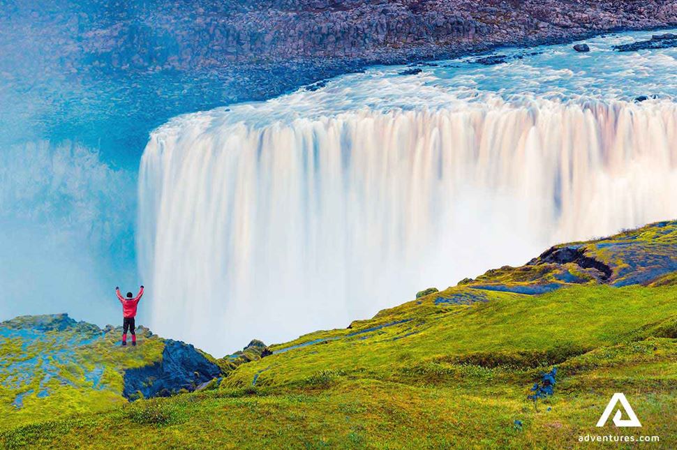 happy hiker near dettifoss waterfall in north iceland