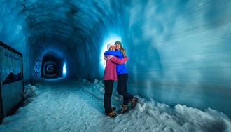 Two friends hugging posing for photo inside Langjokull ice tunnel 