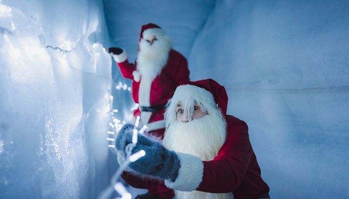 Two Yule Lads Hanging Lights In An Ice Tunnel in iceland