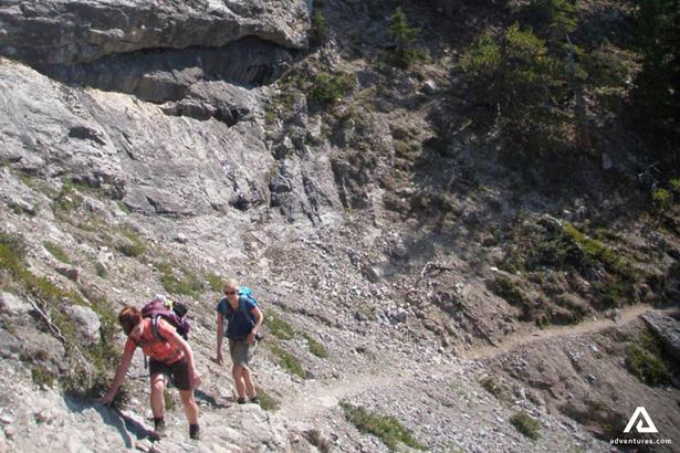 Two People Hiking on Cliffs in Rocky Mountains