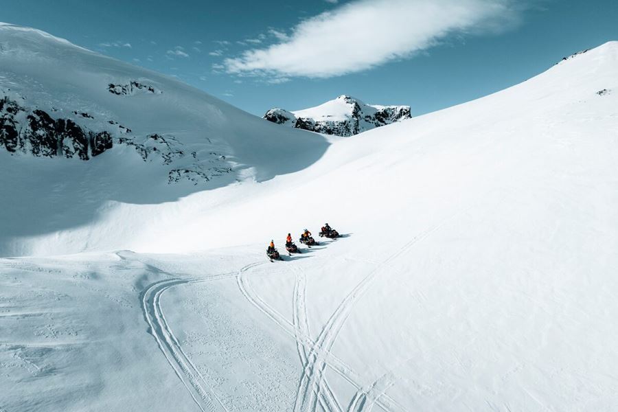 Four Snowmobiles Standing On A Hill On Langjokull Glacier