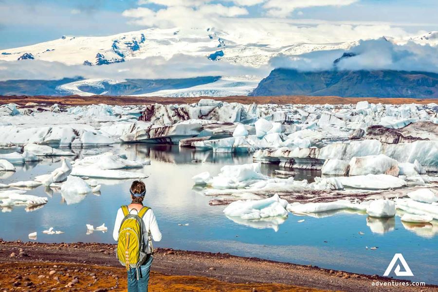 a man walking around the glacier lagoon path