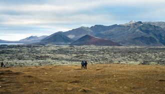 A Pair Of People Standing And Gazing At Snaefellsnes Peninsula in iceland