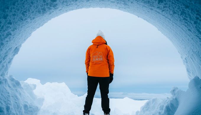Person standing at entrance of Langjokull ice tunnel in snowy weather