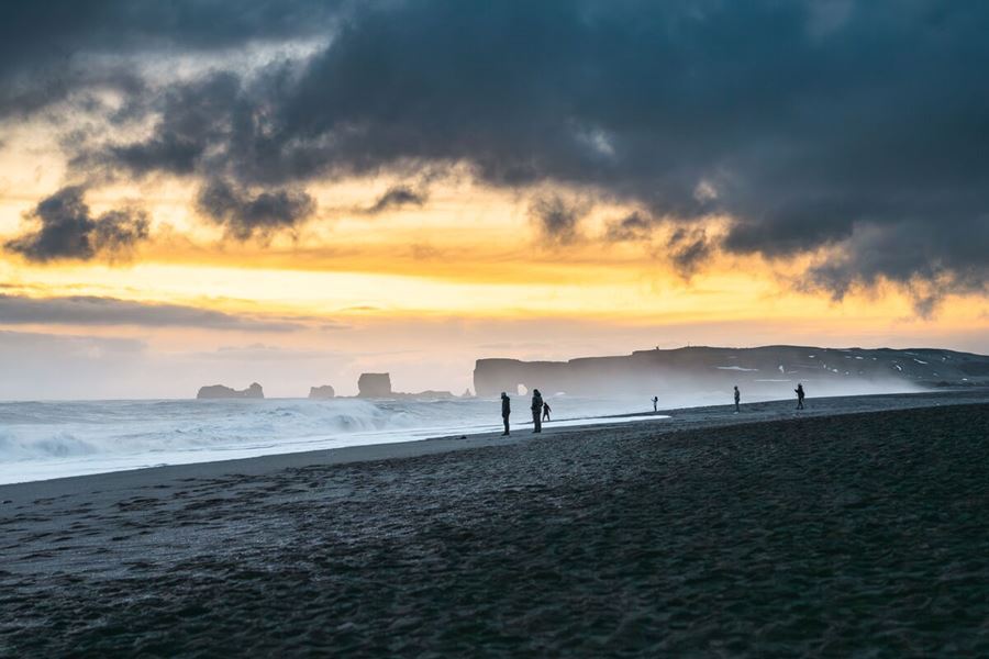 People At A Black Sand Beach In Iceland reynisfjara