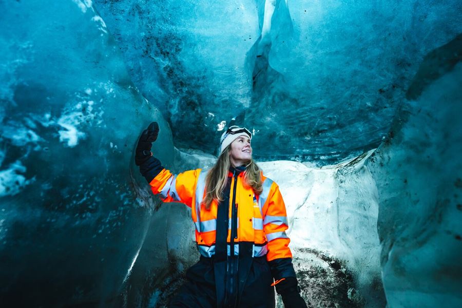 Woman Touching And Admiring The Inside Of An Ice Cave