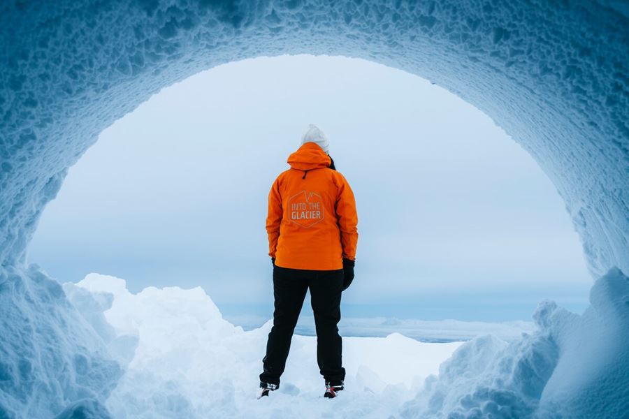 Person standing at entrance of Langjokull ice tunnel in snowy weather