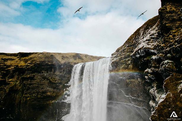 rainbow over skogafoss waterfall in iceland