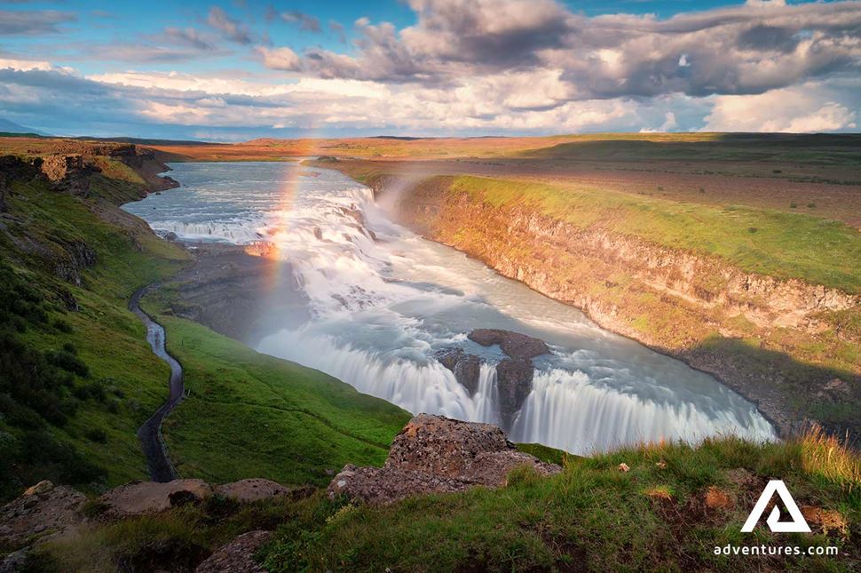 long rainbow over gullfoss waterfall in iceland
