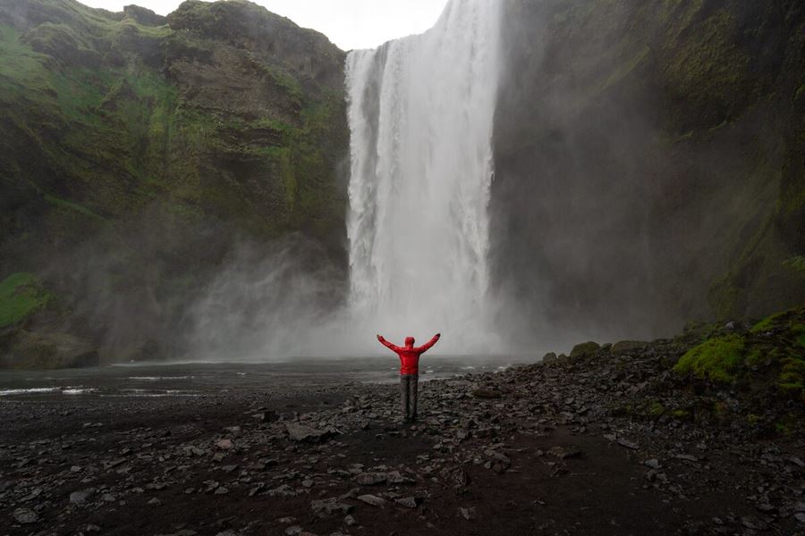 Excited woman by Skogafoss Waterfall