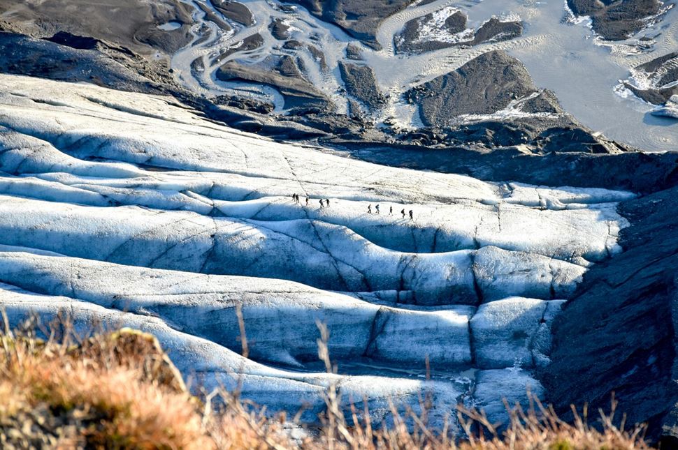 Aerial view of Sólheimajökull Glacier Hikers walking across glacier 
