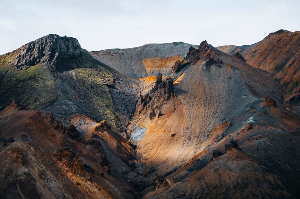 Landmannalaugar different colored mountain with sun beaming down 