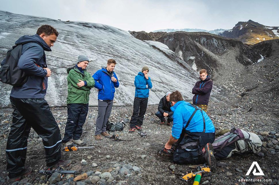 guide showing how to put on crampons before a tour