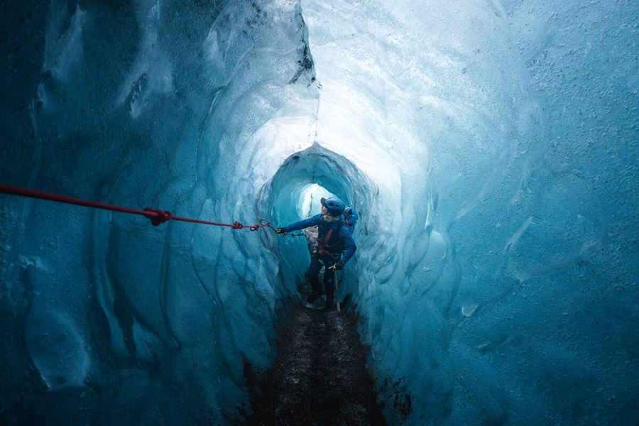 Glacier guide exploring ice cave