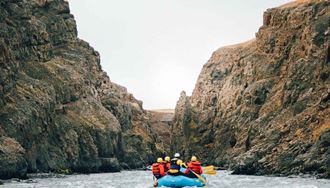 Glacial River Rafting Between Rocks