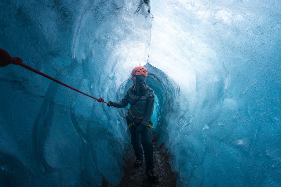 Excited woman in long blue ice tunnel