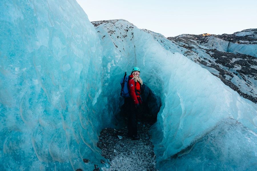 Female Smiling Standing at Ice Formation Opening 