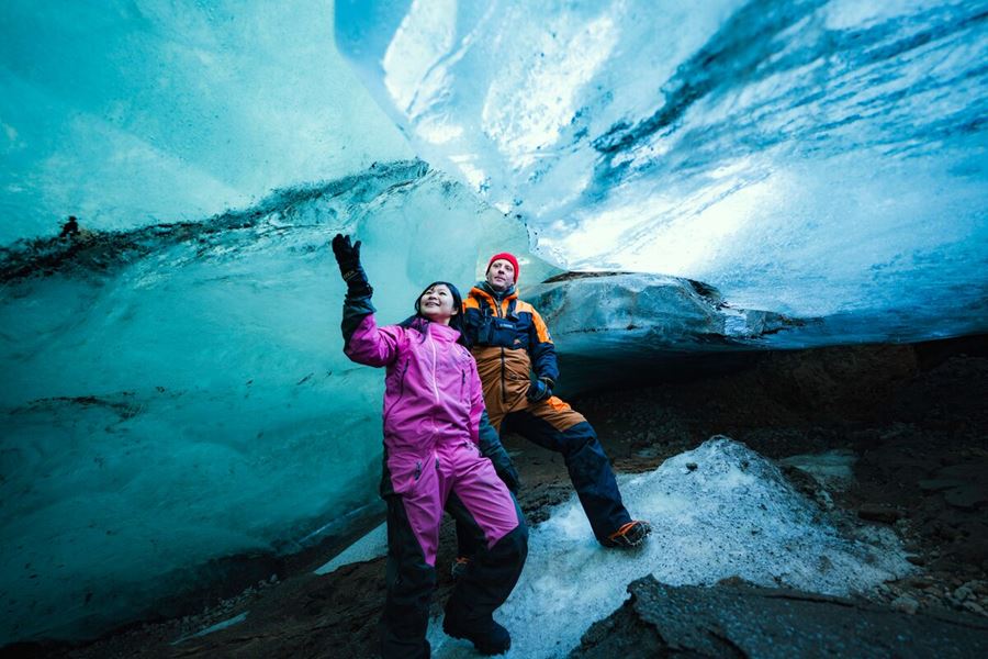 a couple in an ice cave touching ice