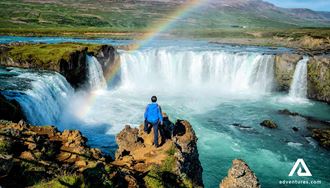 man standing near godafoss waterfall
