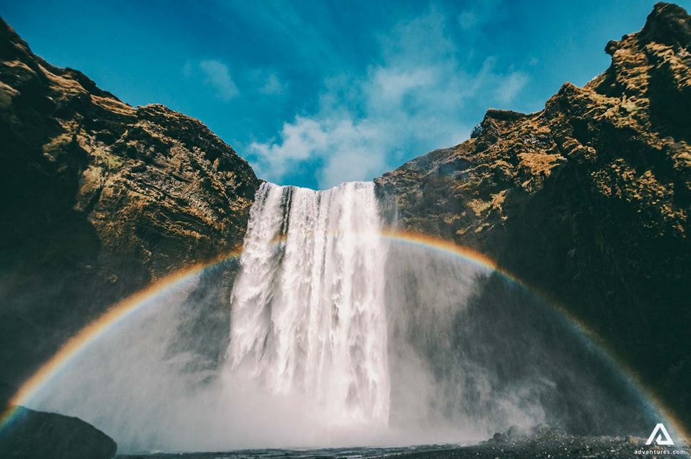 rainbow over skoga river waterfall in iceland