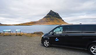 A Car Standing In Front Of Kirkjufell Mountain