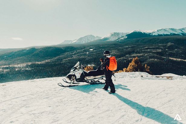 approaching a snowmobile in canada on a mountain