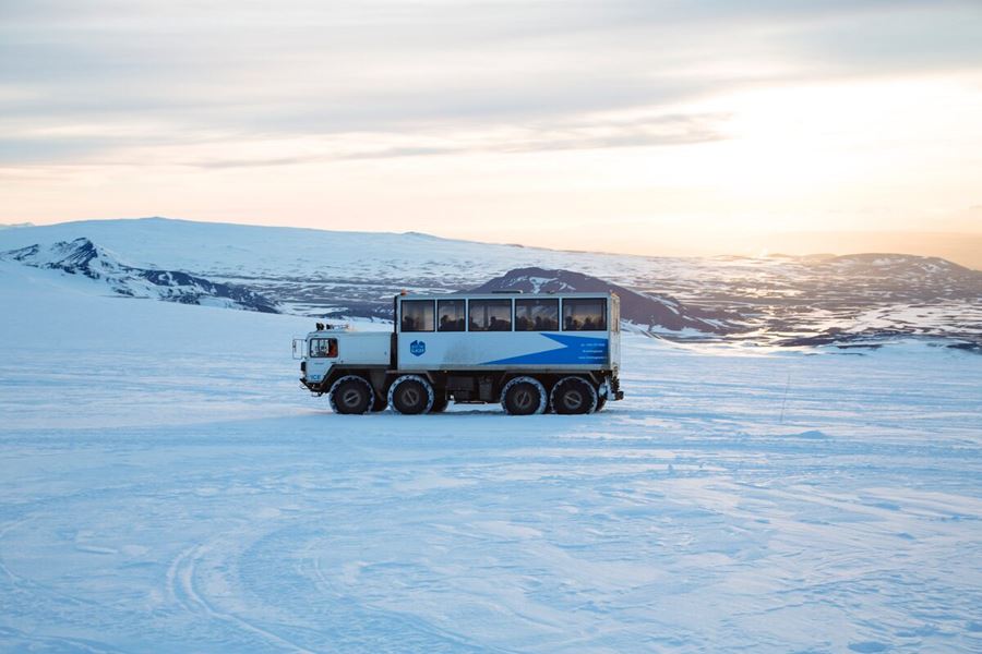 Monster truck driving on Langjokull glacier during sunset