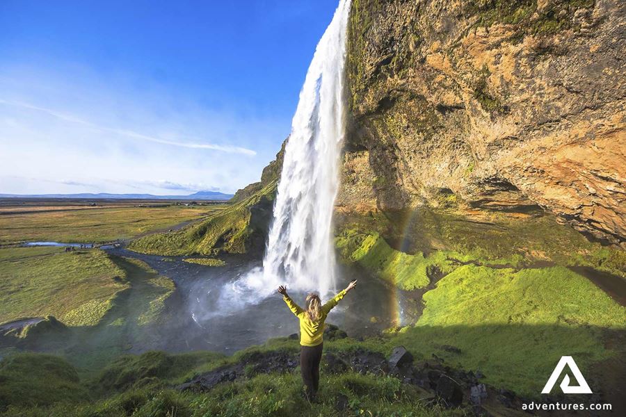 happy woman spreading arms near seljalandsfoss