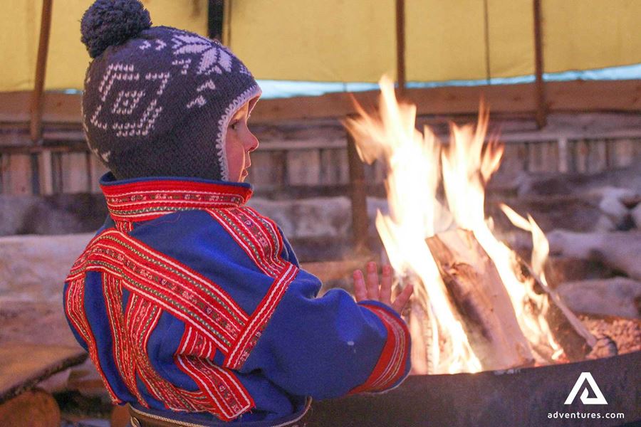 young boy near a campfire