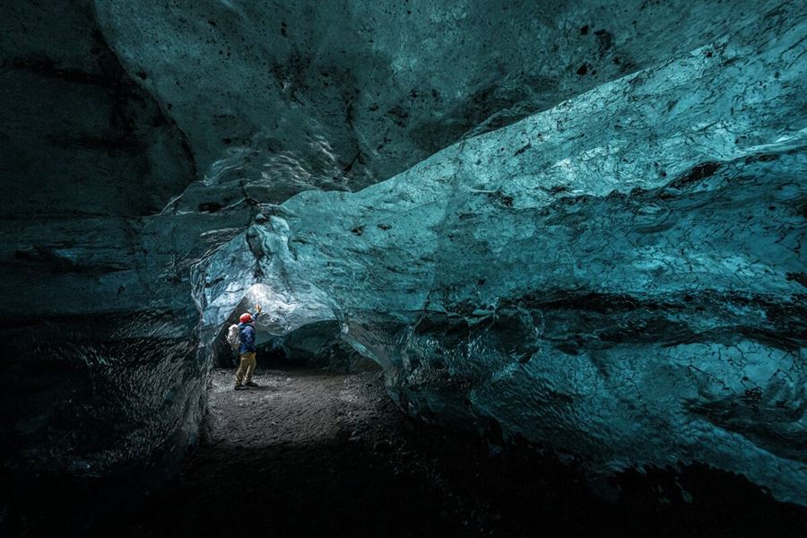 Inside Blue crystal ice cave with reflecting light shining onto ice cave walls at Vatnajokull, 2025.