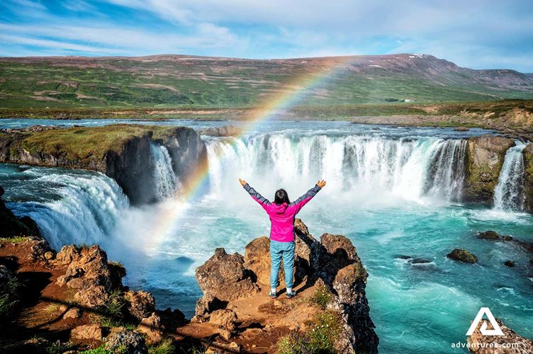happy woman at godafoss waterfall
